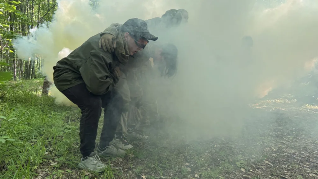 Люди тренуються в димовій завісі в лісі