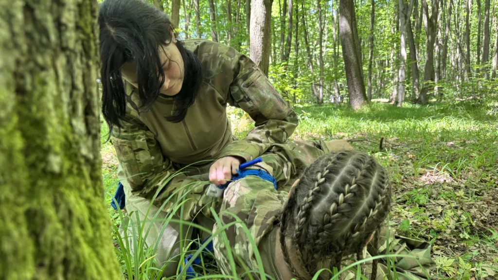 Військова надає першу допомогу в лісі