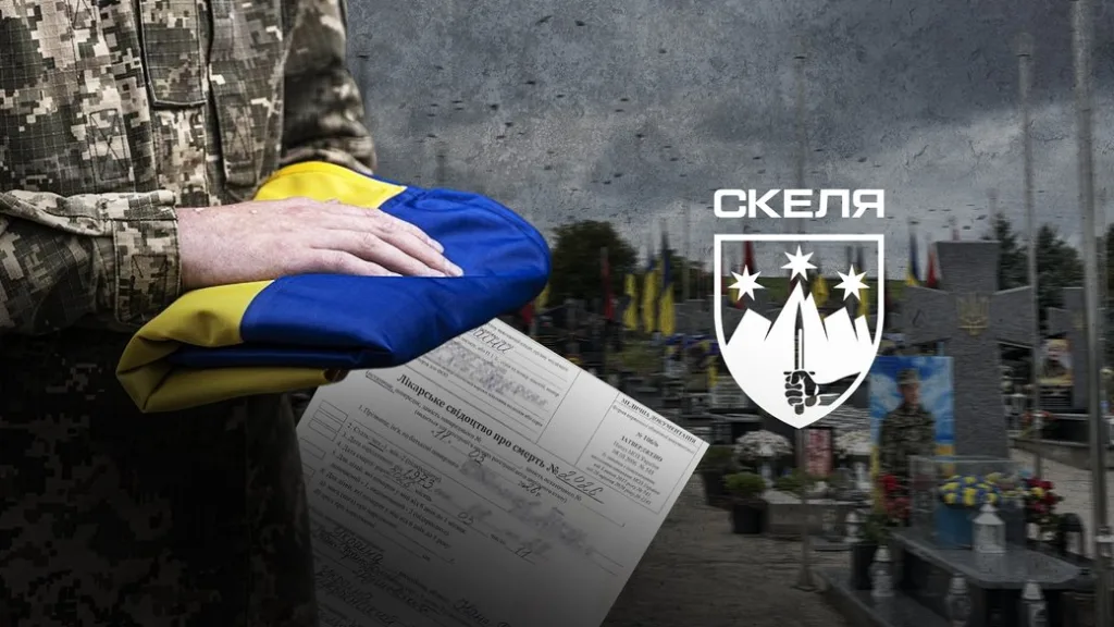 Військовий тримає український прапор на цвинтарі
