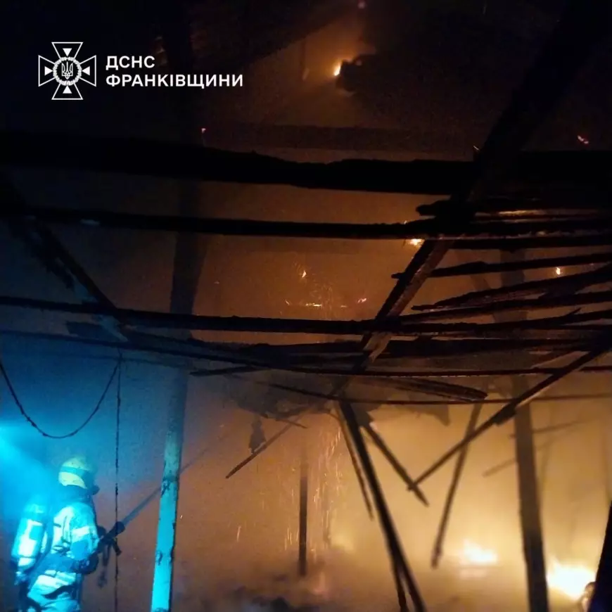 Пожежник гасить вогонь у темній будівлі