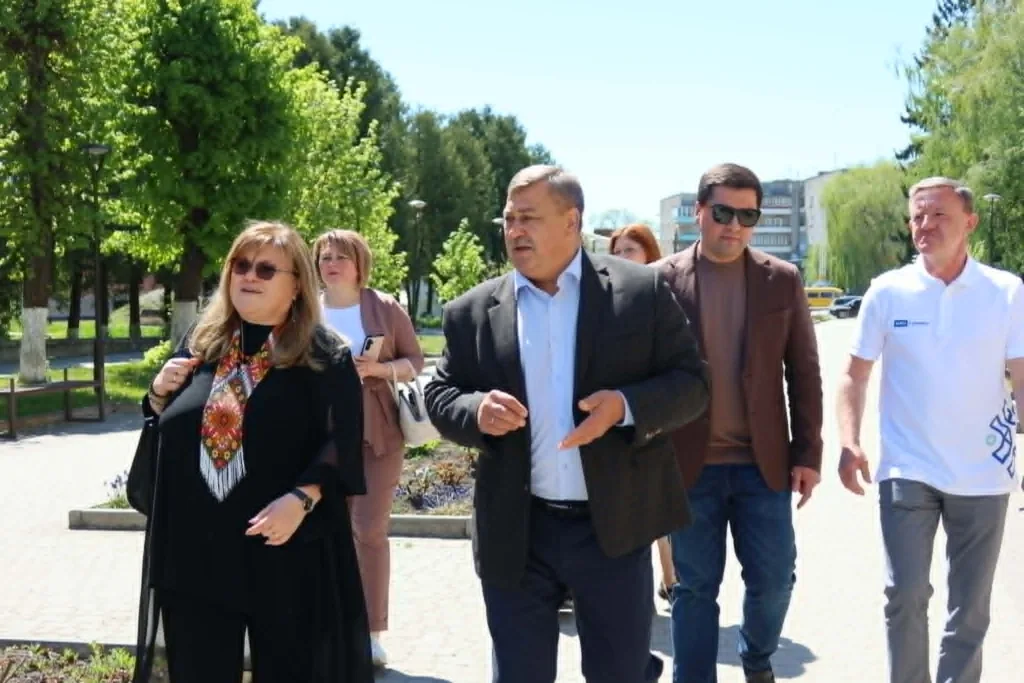 Люди йдуть парком під час сонячного дня