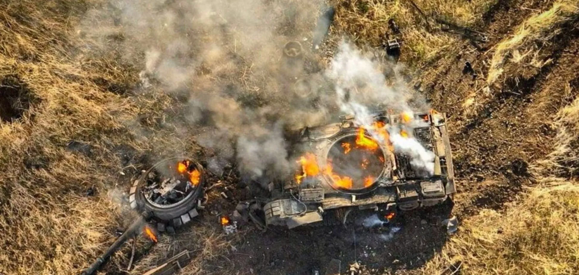 Знищений танк горить на полі бою