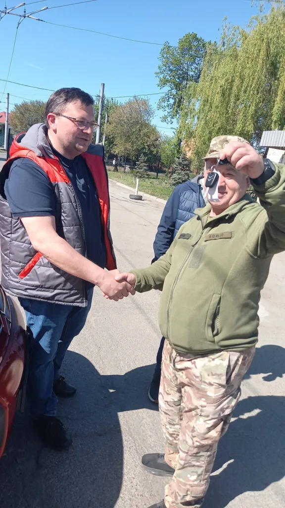Двоє чоловіків тиснуть руки на вулиці
