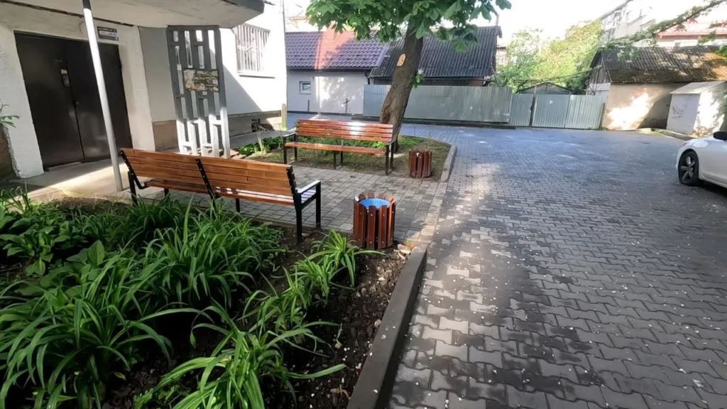 Двір із лавками, деревом та клумбами біля під'їзду