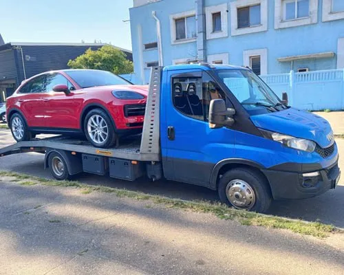 Червоний автомобіль на синьому евакуаторі