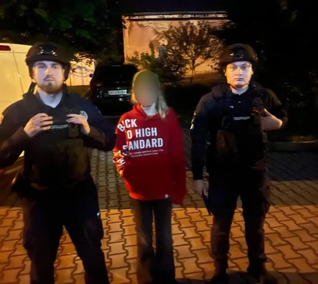 Поліцейські поруч із людиною в червоній кофті