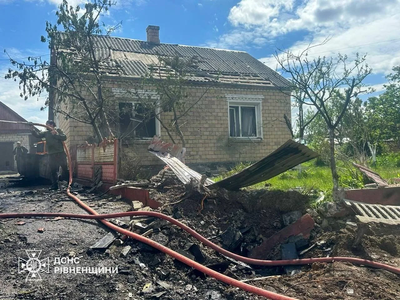 Пожежники гасять пожежу біля зруйнованого будинку