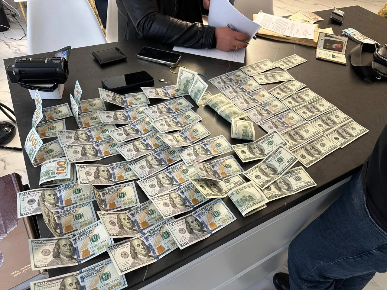 Стіл з великою кількістю стодоларових купюр