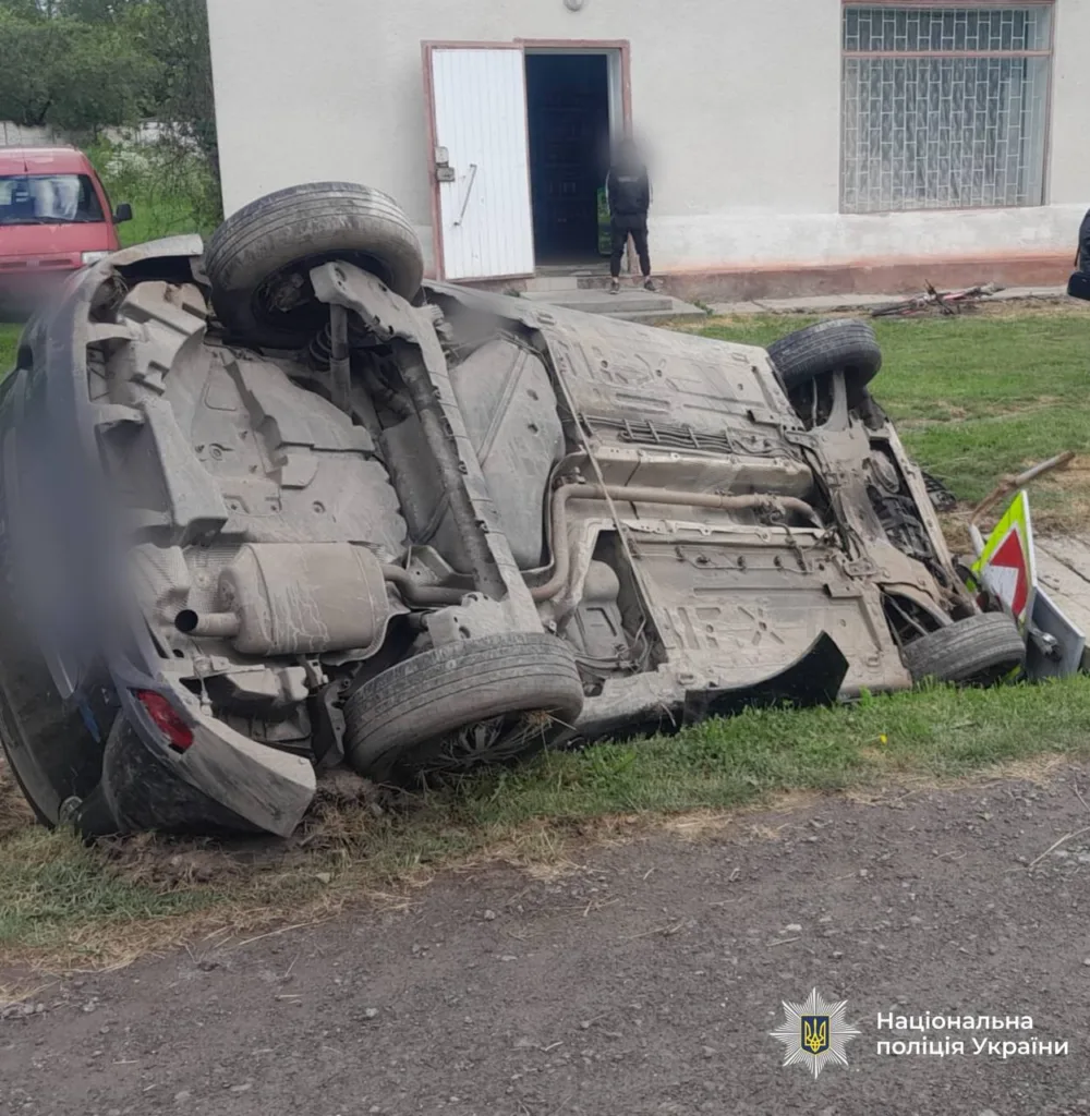 Перекинутий автомобіль біля будівлі після аварії
