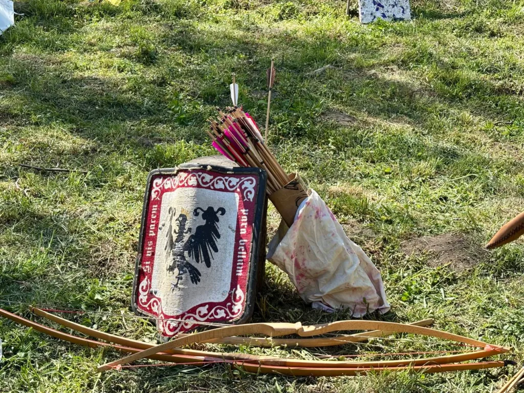 Середньовічний щит, лук і стріли на траві