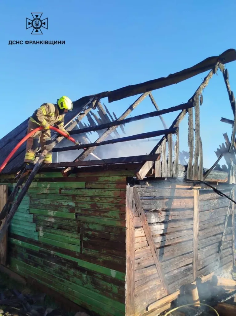 Рятувальник гасить пожежу у дерев’яній будівлі