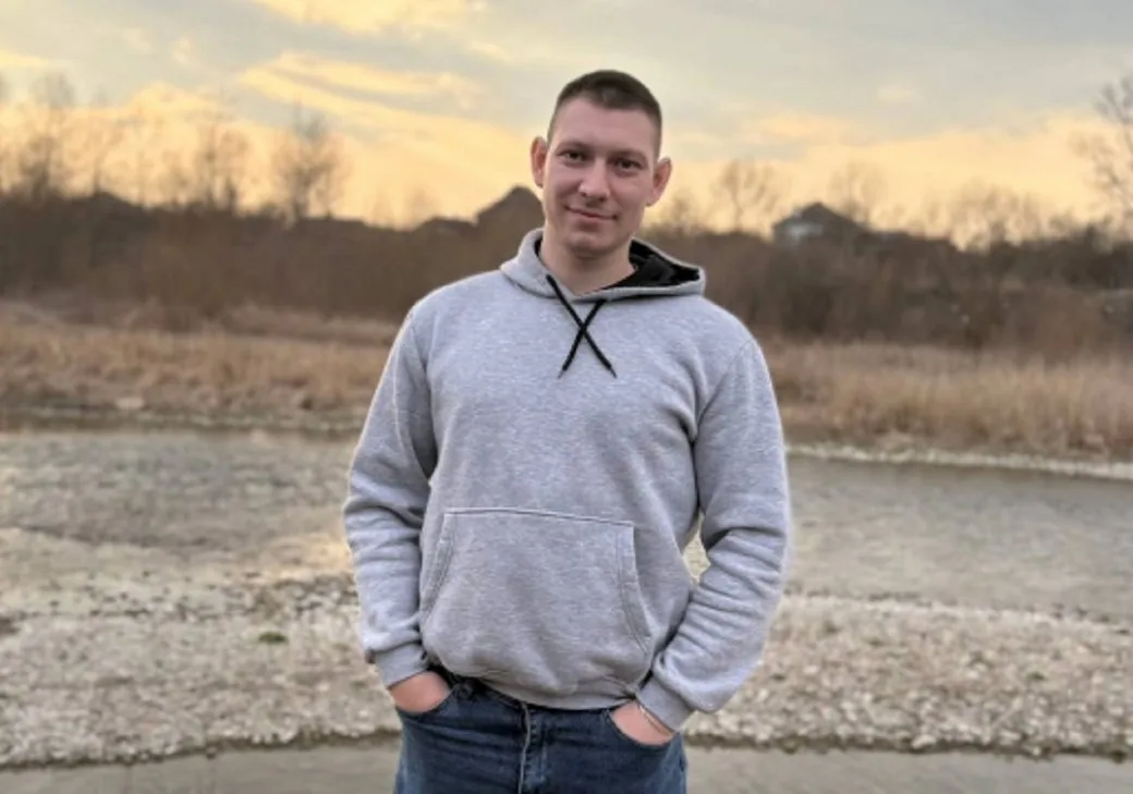 Чоловік у сірій толстовці на природі восени