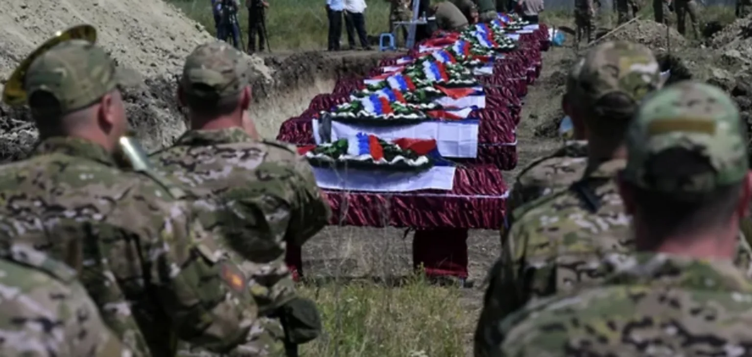 Військові на похороні з трунами, вкритими прапорами