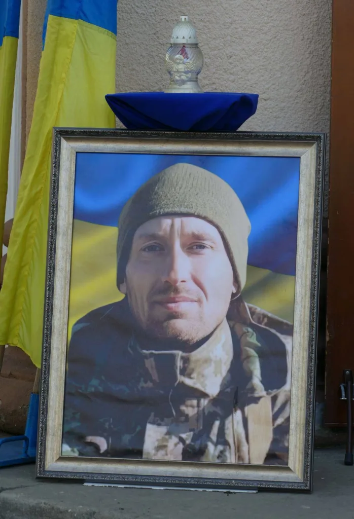 Портрет військового перед прапором України