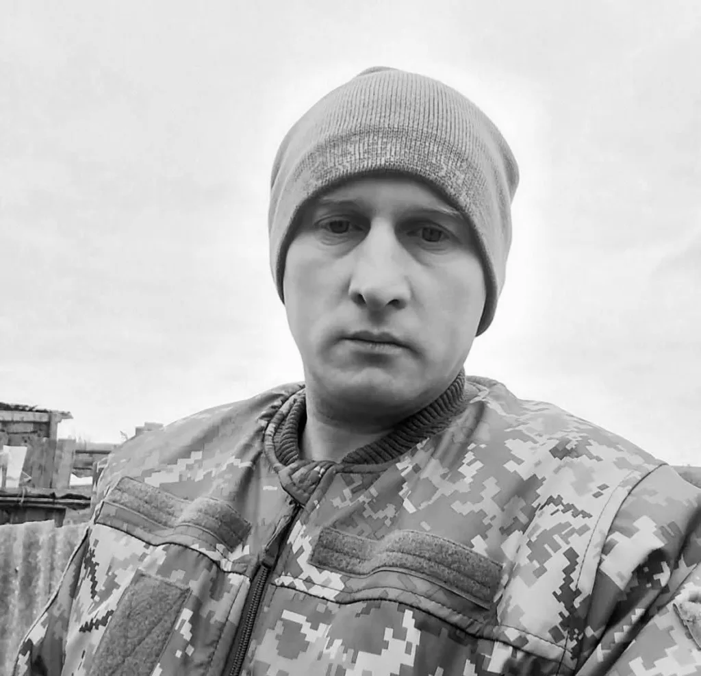 Чоловік у камуфляжній куртці та шапці