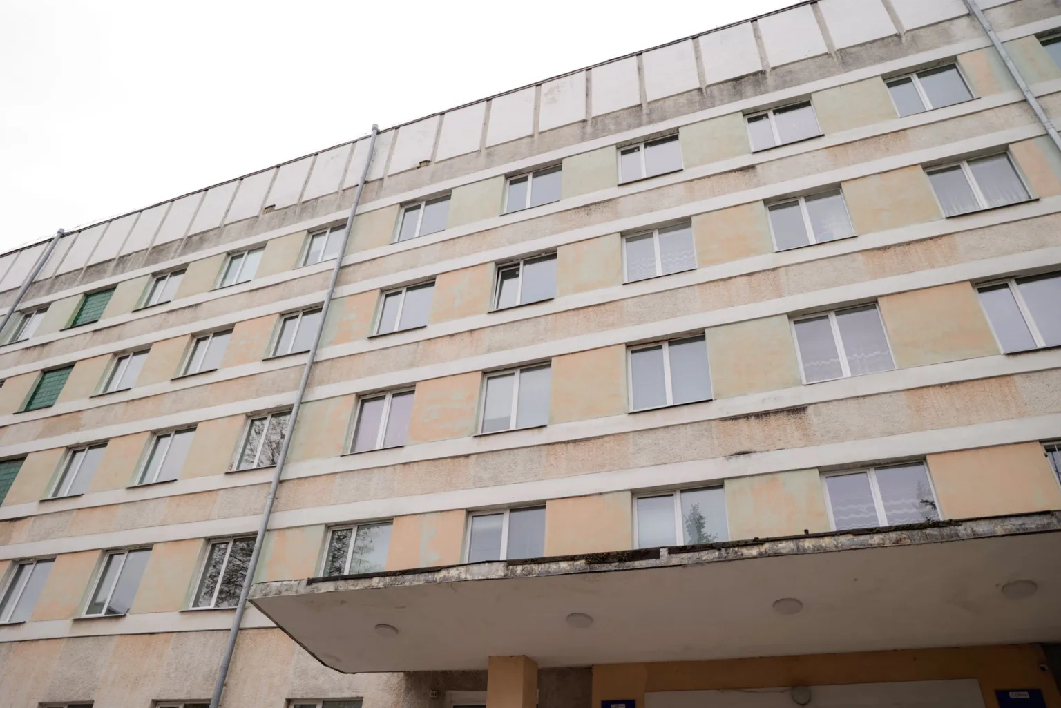 Старий п'ятиповерховий житловий будинок з вікнами