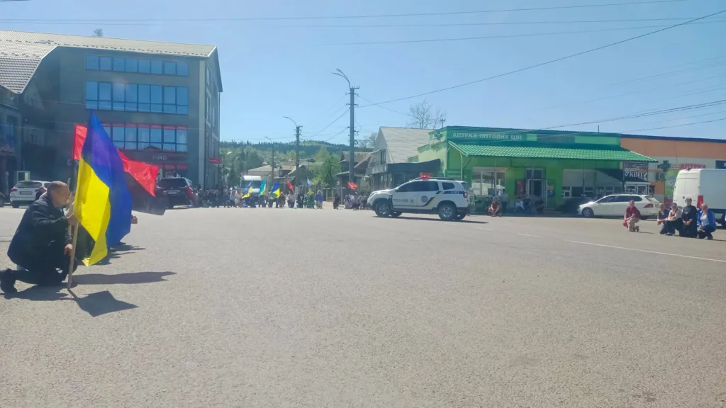 Люди з українськими прапорами на міській вулиці