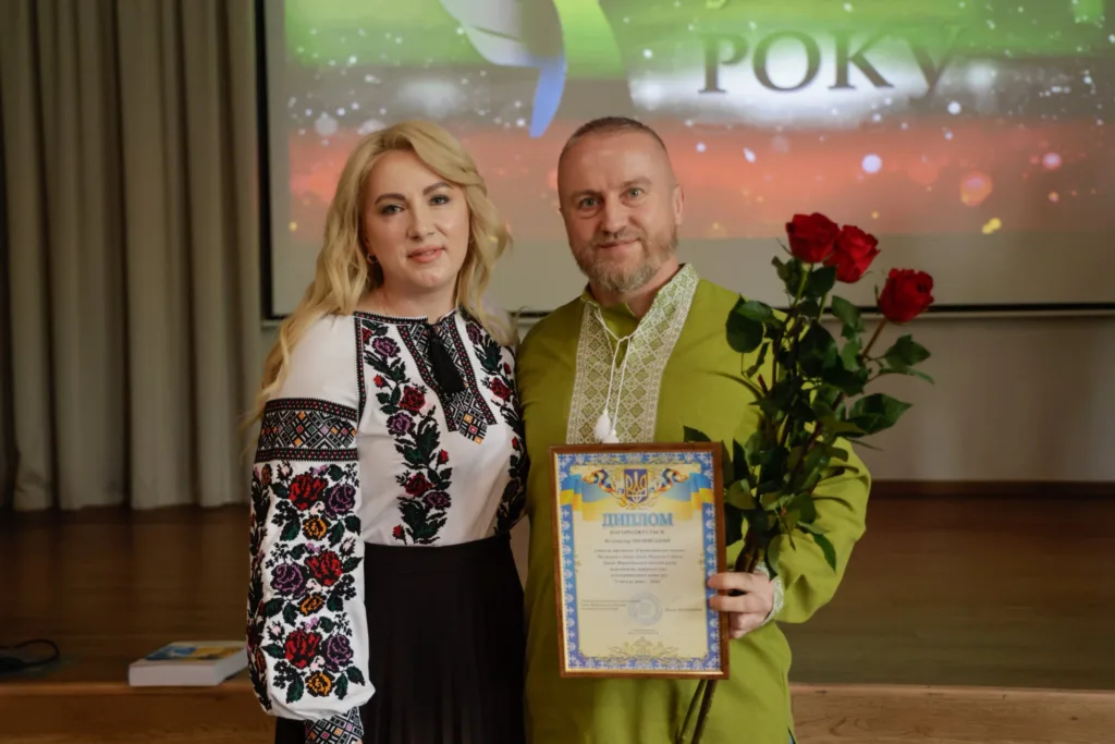 Нагородження дипломом і червоними трояндами на сцені
