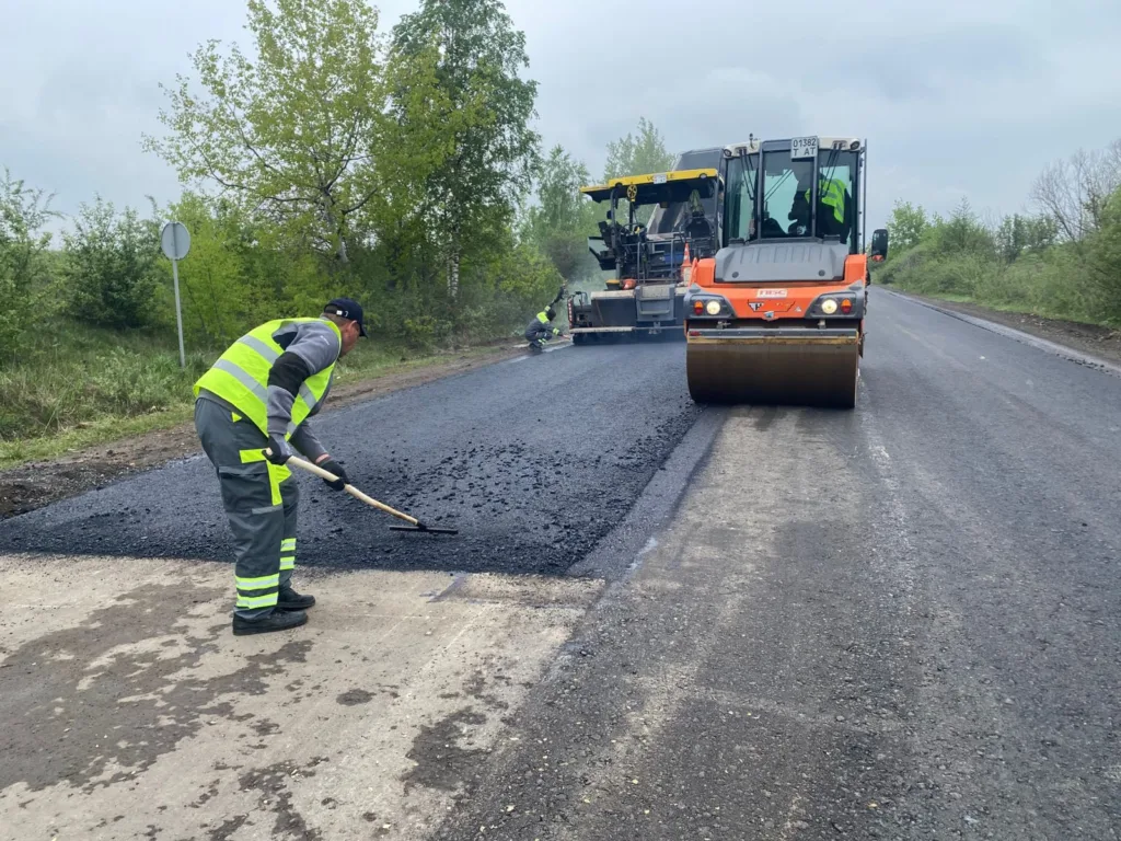Робітники ремонтують асфальтну дорогу