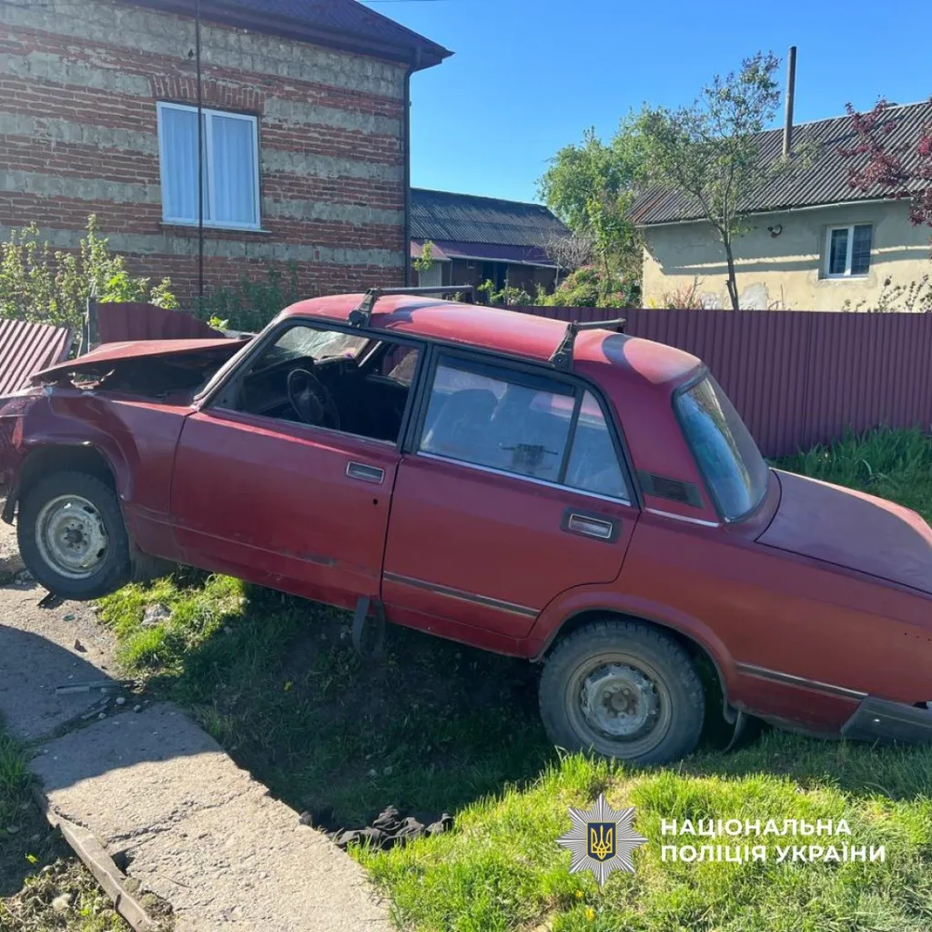 Червоний автомобіль врізався у паркан біля будинку