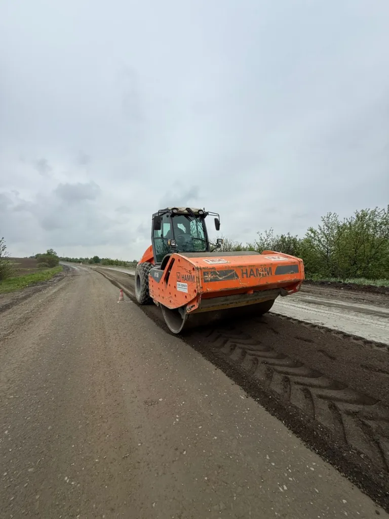 Дорожній каток ущільнює ґрунт на заміській дорозі