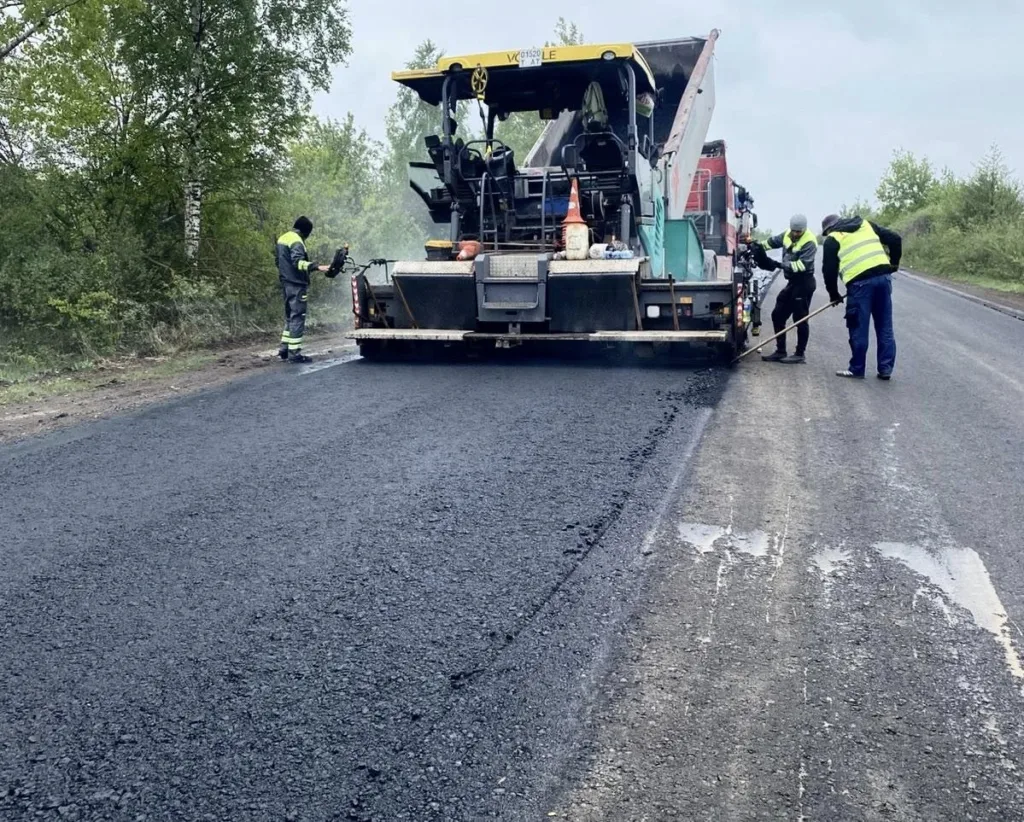 Робітники асфальтують дорогу дорожньою технікою