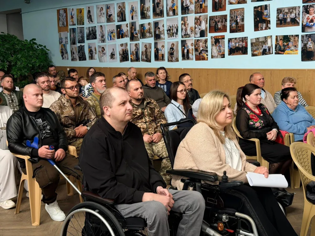 Люди на зустрічі у залі з фотографіями