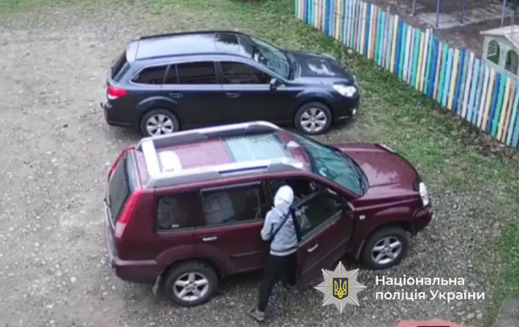 Людина біля червоного авто, фото поліції України