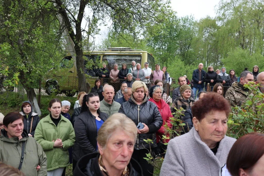 Люди зібралися на вулиці серед зелених дерев