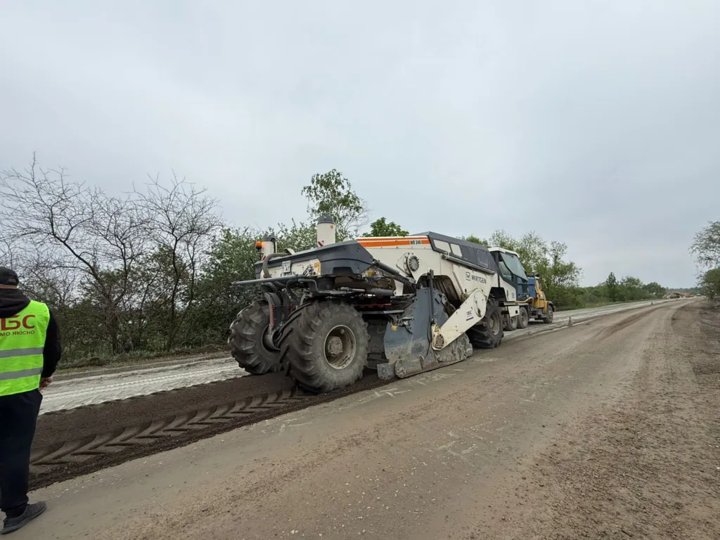 Будівництво дороги важкою технікою на заміській трасі