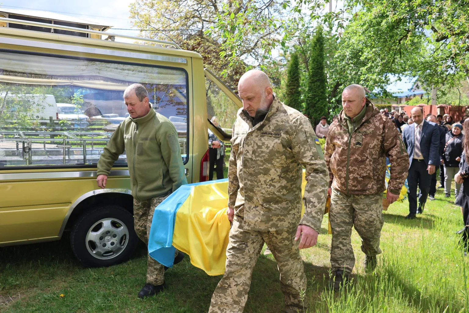 Військові несуть труну, накриту прапором України