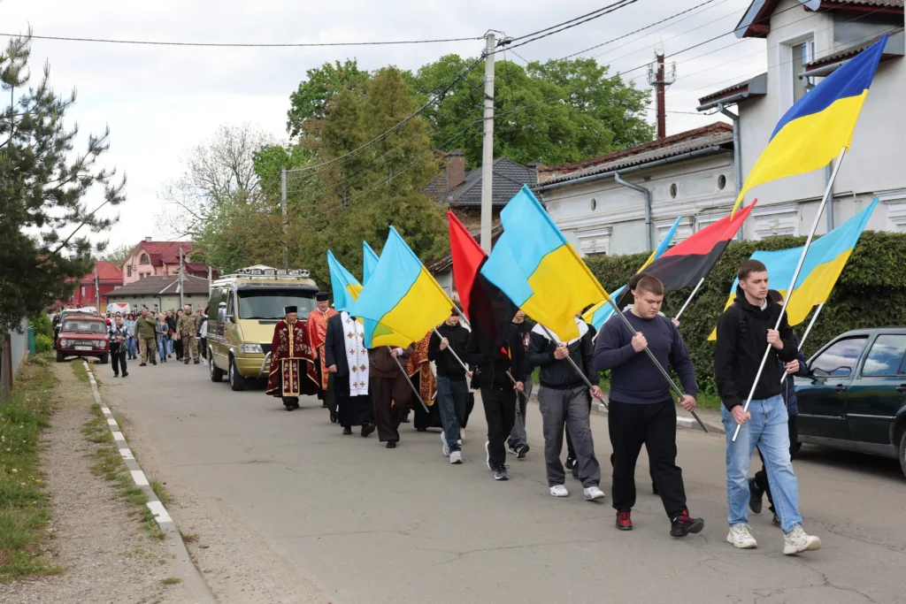 Хода з українськими прапорами на вулиці міста