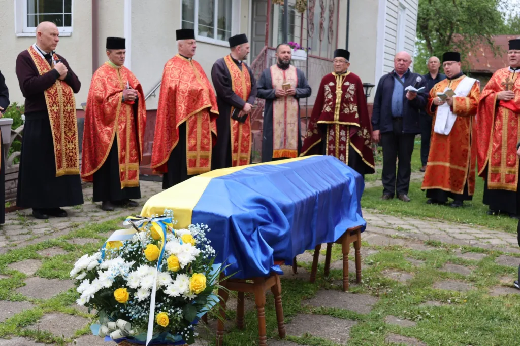 Похоронна церемонія з труною, накритою прапором України