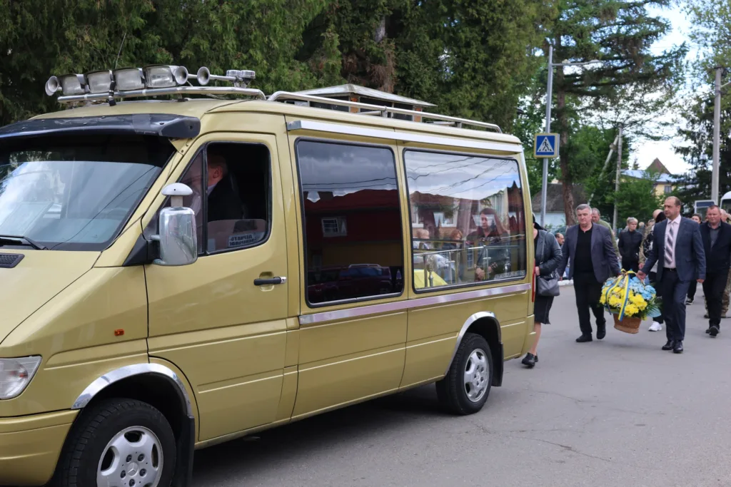 Похоронна процесія біля золотистого мікроавтобуса