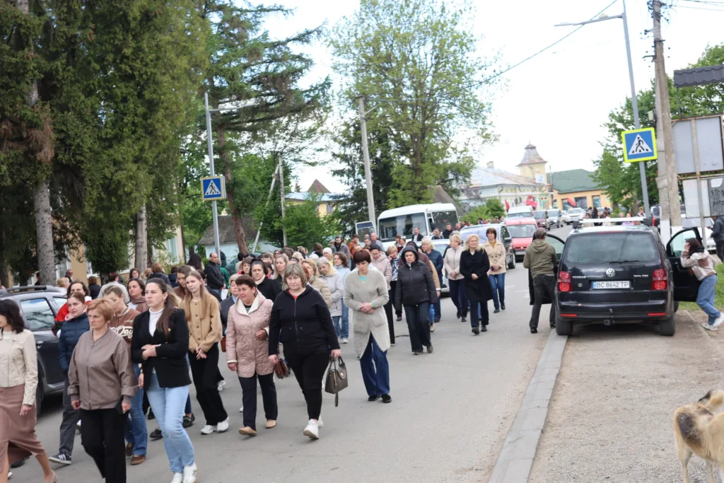 Група людей йде вулицею міста