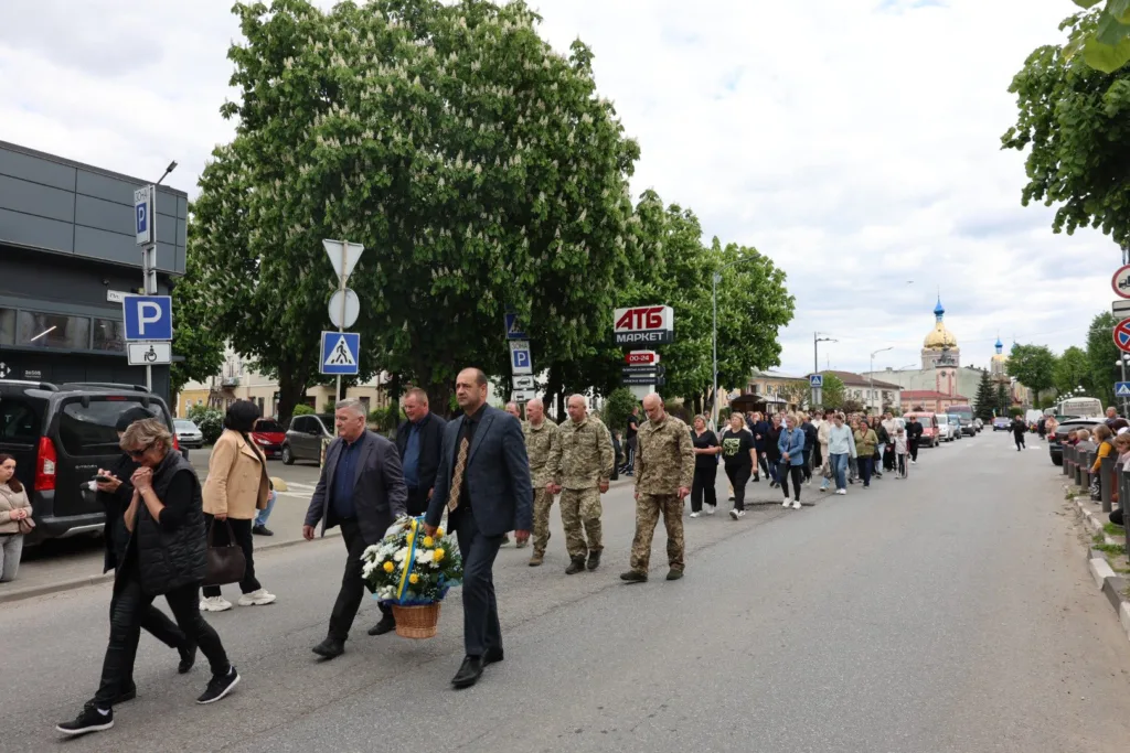 Люди йдуть вулицею під час церемонії пам'яті