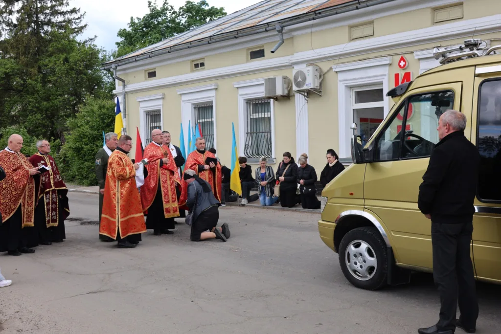 Священики моляться біля золотого мікроавтобуса