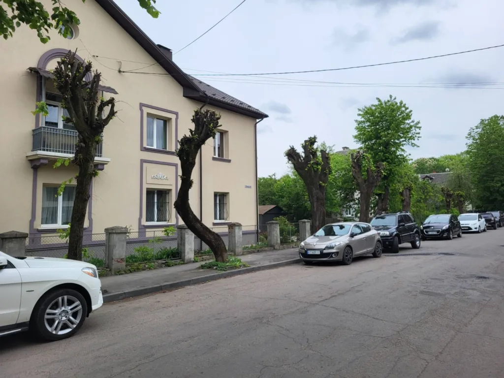 Вулиця з припаркованими авто біля житлового будинку