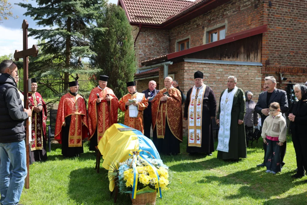 Священики проводять похоронну церемонію біля труни