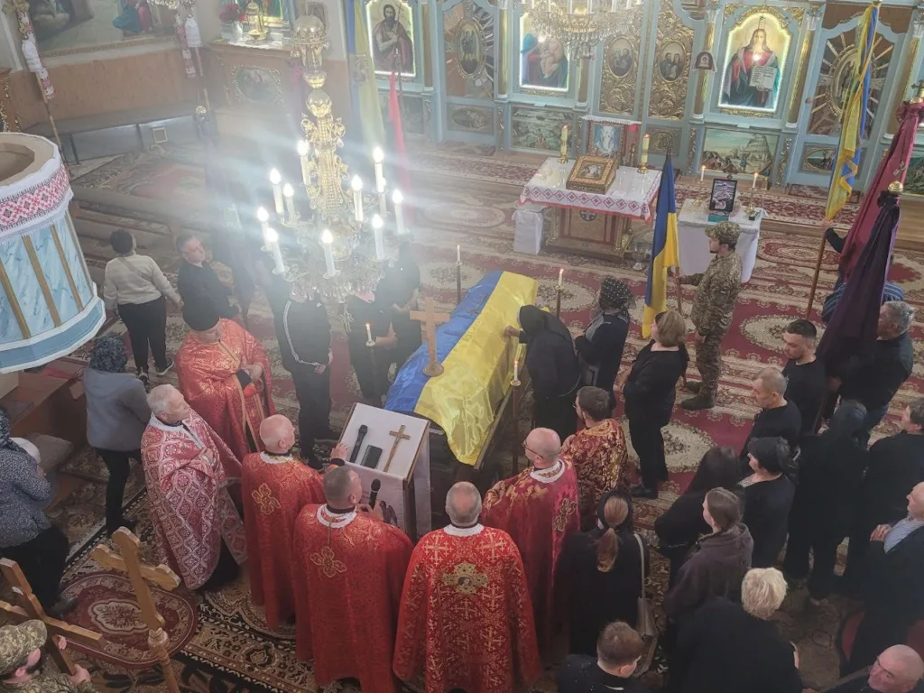 Похоронна церемонія у церкві з українським прапором