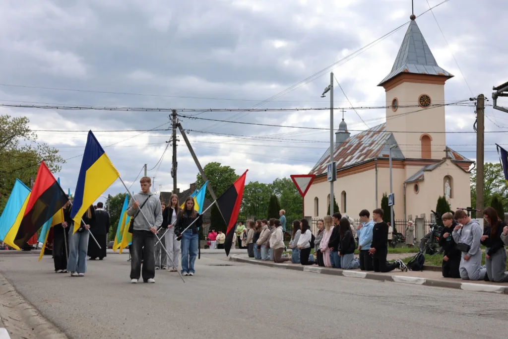 Люди з українськими прапорами біля церкви
