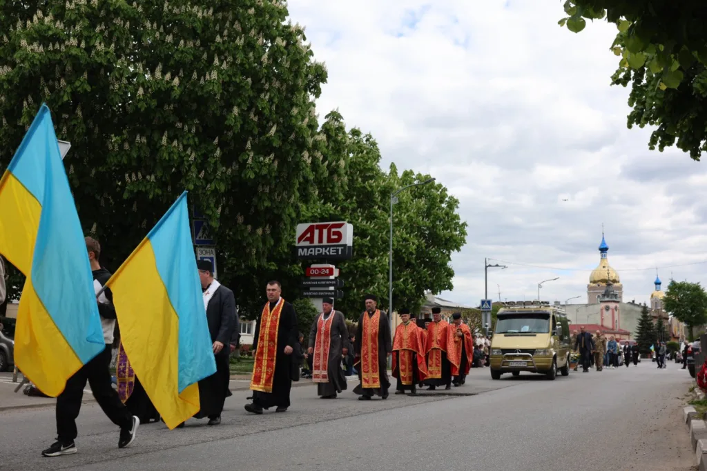 Хода з українськими прапорами та священиками на вулиці