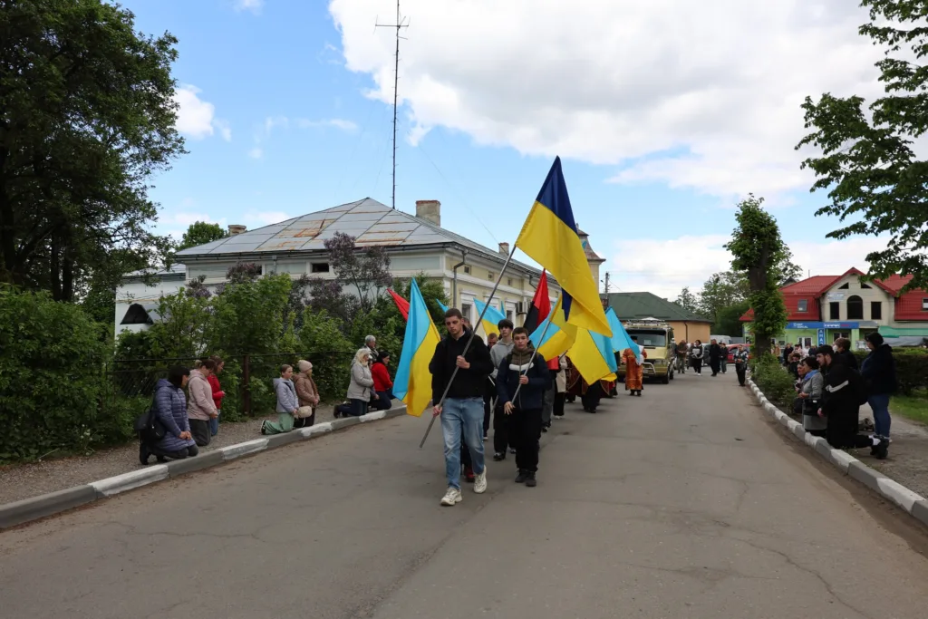 Хода з українськими прапорами на вулиці міста