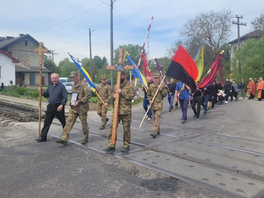 Похоронна процесія військових з українськими прапорами