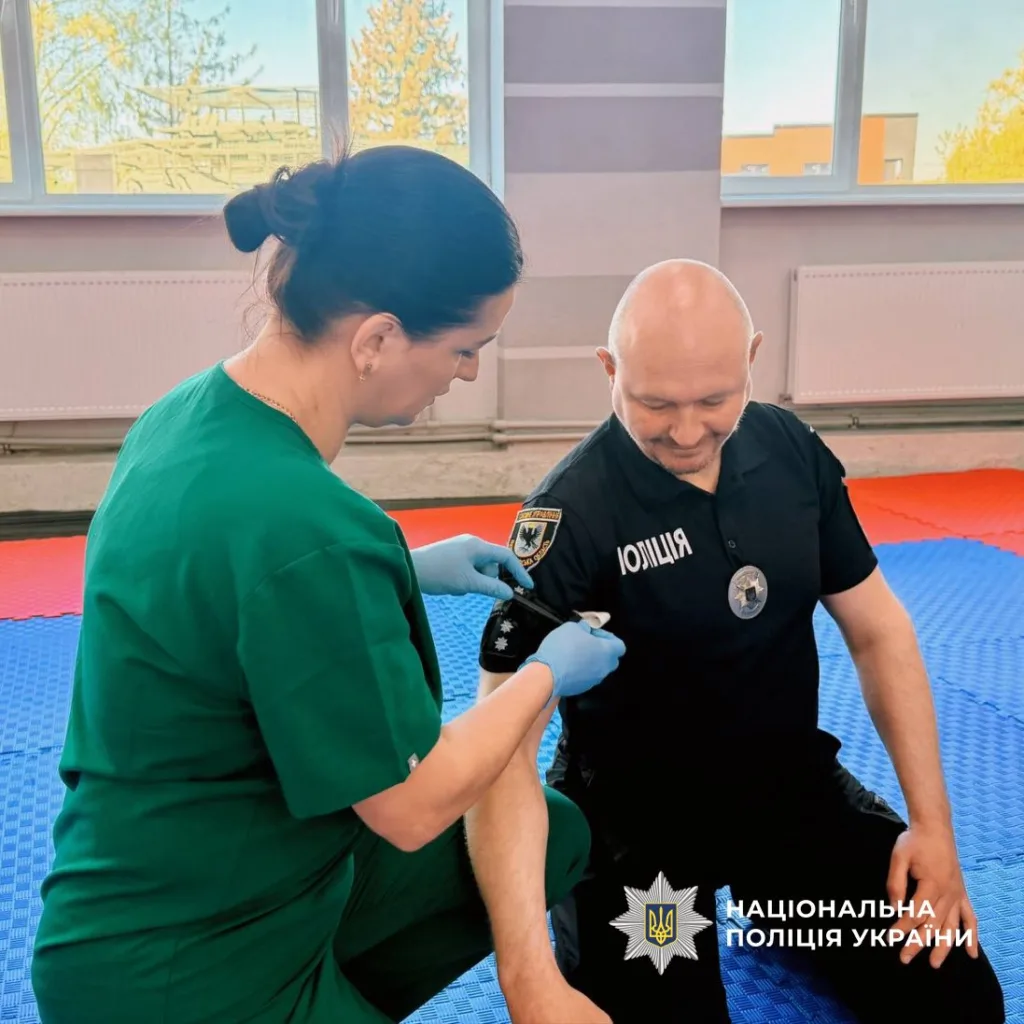 Медик вакцинує поліцейського Національної поліції України