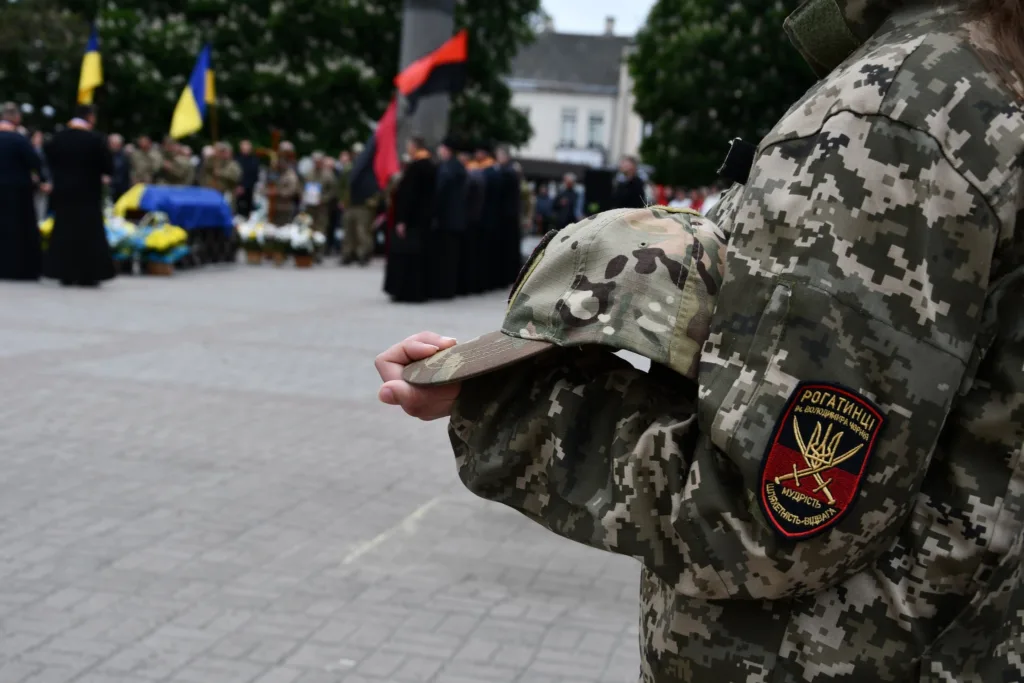 Український військовий тримає кашкет під час церемонії