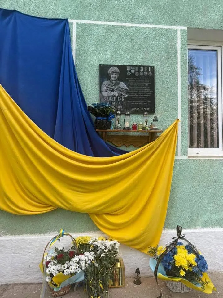 Меморіальна дошка з українським прапором і квітами