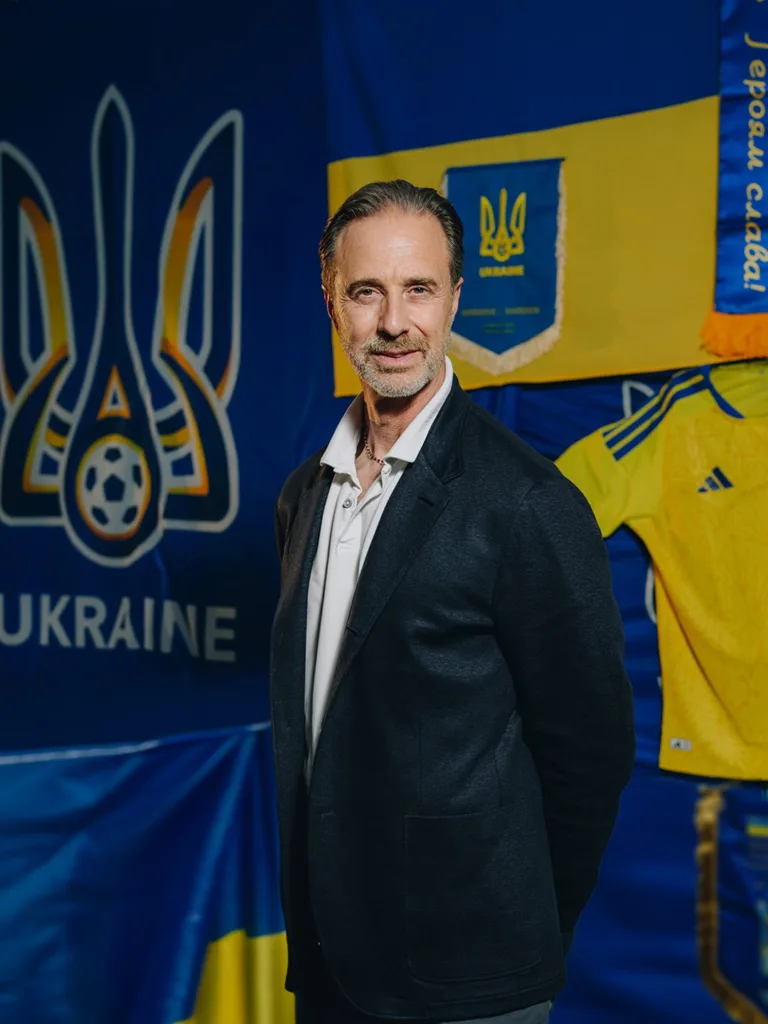 Чоловік перед прапором України та футбольною символікою