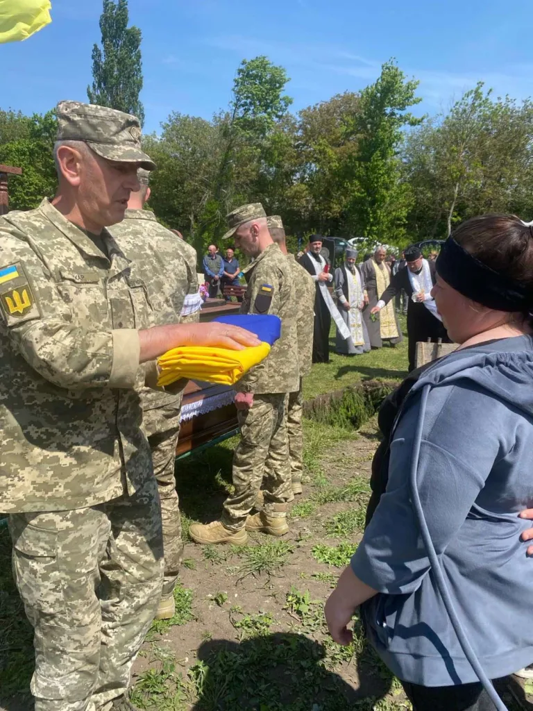 Військові передають прапор на похороні воїна