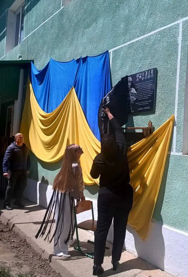 Відкриття меморіальної дошки на тлі прапора України
